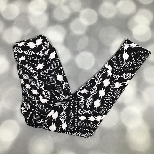 LuLaRoe leggings in Midnight Aztec with bold black-and-white geometric tribal-inspired print. on a blurred gray background
