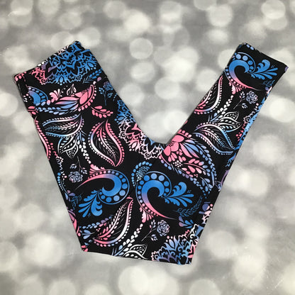 LuLaRoe leggings featuring a black background with pink and blue paisley and floral swirl patterns in an all-over ornamental print on a blurred background
