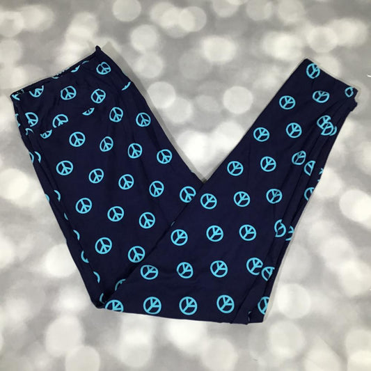 LuLaRoe leggings in a navy blue base with repeating turquoise peace sign symbols, featuring a soft brushed fabric and a comfortable stretch fit for everyday wear on a blurred light gray background