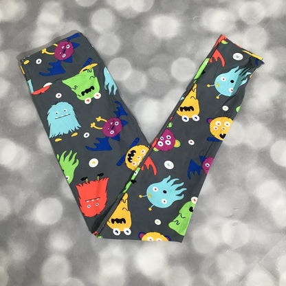 LuLaRoe leggings featuring gray background with colorful cartoon monster print in red, teal, yellow, green, and purple on a gray background