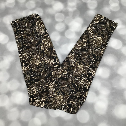 LuLaRoe leggings in Noir Baroque Bloom with black background, ornate ivory floral paisley print, and soft stretchy fabric on a blurred background