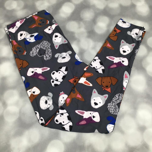 LuLaRoe leggings with a playful dog face print in white and brown tones on a charcoal gray background, shown in flat lay on a gray background