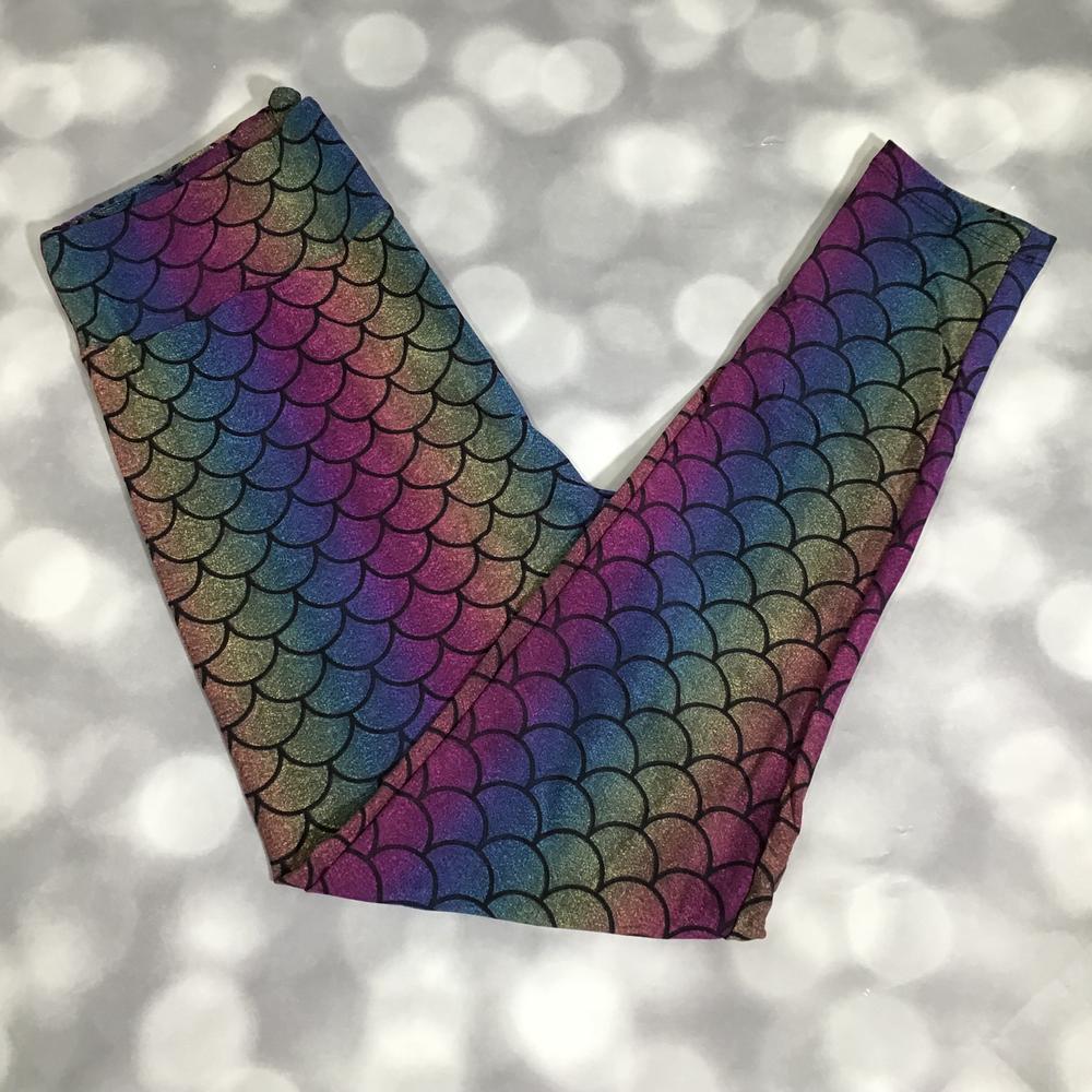 LuLaRoe leggings laid flat featuring a rainbow mermaid scale pattern in teal, purple, blue, green, and pink iridescent gradient design on a light background
