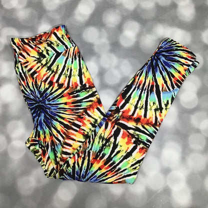LuLaRoe leggings with a rainbow tie-dye spiral pattern featuring bold black burst lines, laid flat with crossed legs on a gray background