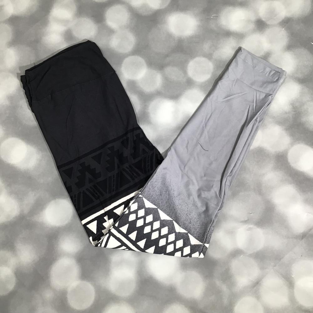 LuLaRoe leggings featuring black to gray ombre design with bold black and white geometric tribal border print on a textured surface