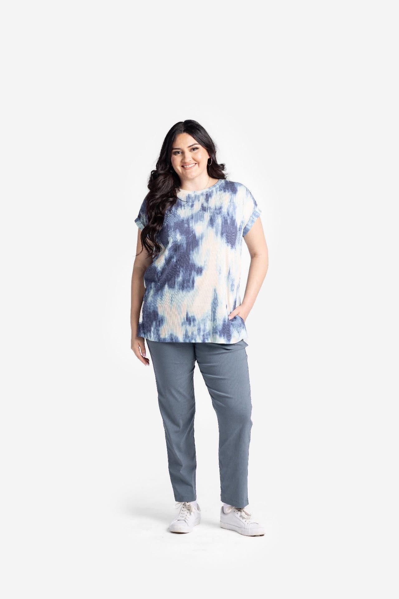 Model wearing LuLaRoe Lena Work-Leisure Pants in Solid Steel Slate gray featuring a cool-toned slate gray solid color with ankle length straight leg fit styled with a blue tie-dye top and white sneakers on a white background