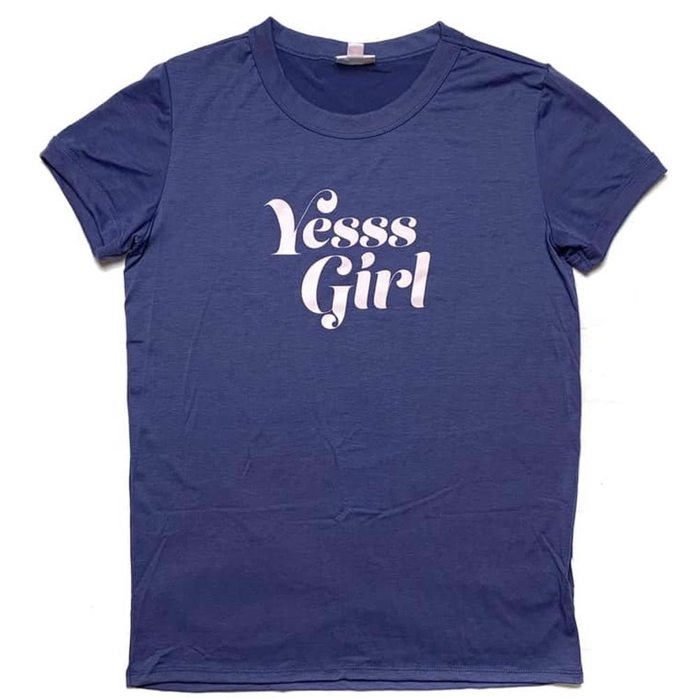 LuLaRoe Liv T in navy blue with ‘Yesss Girl’ text graphic in white” | “Front view of LuLaRoe Liv T on flat lay featuring navy background and bold white ‘Yesss Girl’ lettering in retro-style font on a white background