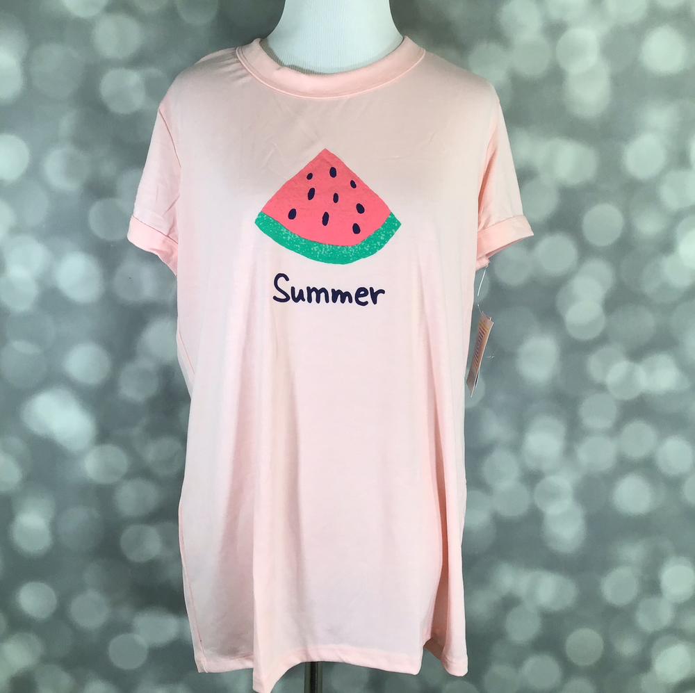 LuLaRoe Liv tee in blush pink featuring a watermelon slice graphic with the word "Summer", short sleeves, crew neckline, relaxed fit, displayed on a mannequin on a blurred gray background