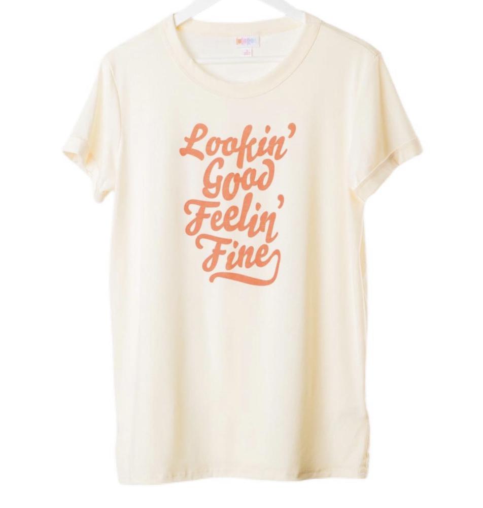 LuLaRoe Liv short sleeve cream T-shirt featuring coral-orange retro text that reads “Lookin’ Good Feelin’ Fine.” Displayed on a hanger with relaxed fit.
