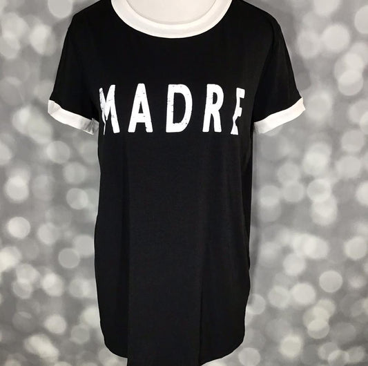 LuLaRoe Liv Tee in black with bold white “MADRE” graphic and contrast white trim at neckline and sleeves.
a blurred gray background