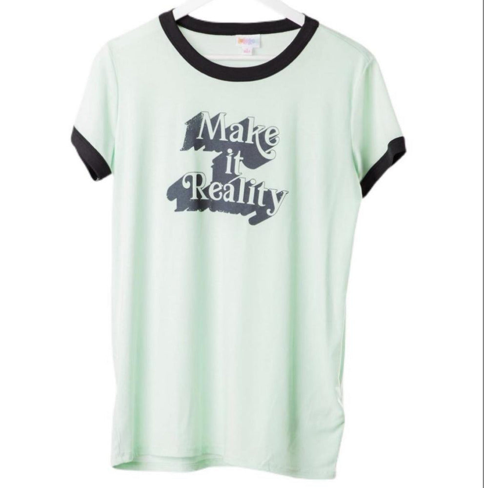 LuLaRoe Liv Tee in mint green with black trim and “Make It Reality” graphic text, featuring short sleeves, relaxed fit, and curved hem displayed on a hanger on a white background