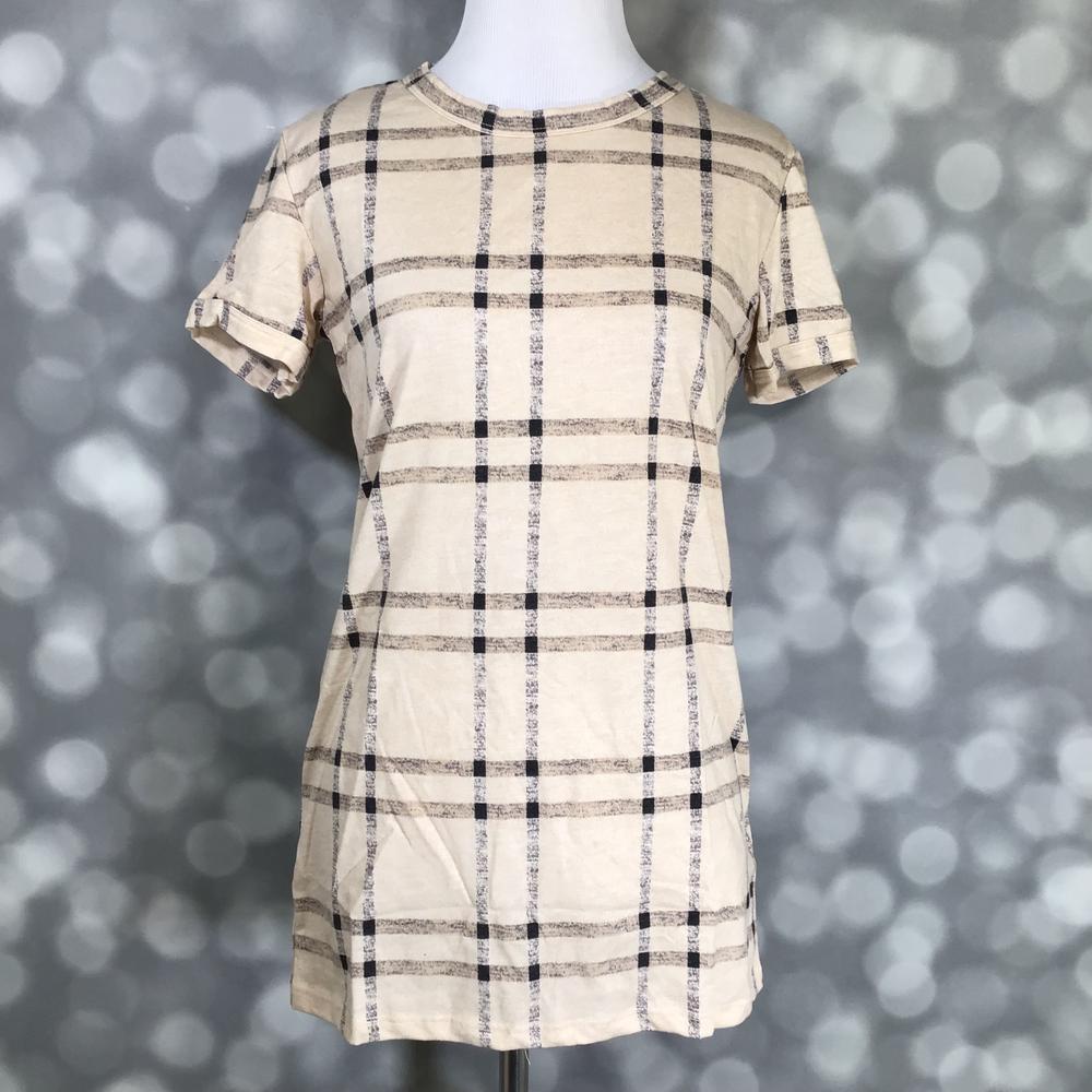 LuLaRoe Liv Tee in beige with black and taupe windowpane plaid pattern, short sleeve relaxed fit on a mannequin against a blurred gray background