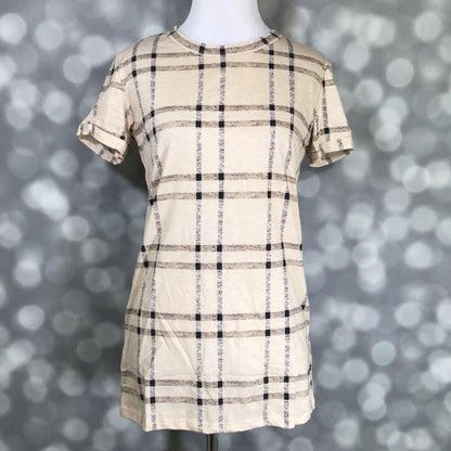 LuLaRoe Liv Tee in beige with black and taupe windowpane plaid pattern, short sleeve relaxed fit on a mannequin against a blurred gray background