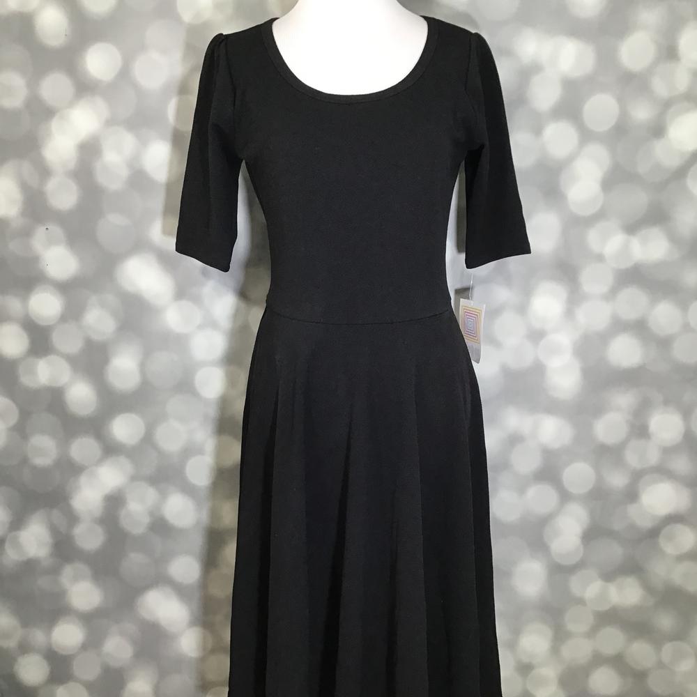 LuLaRoe Nicole Dress in solid black featuring a fitted bodice, scoop neckline, mid-length sleeves, and a full circle skirt. Women's classic black fit and flare dress designed for workwear, special occasions, church outfits, casual styling, and year-round wardrobe versatility.