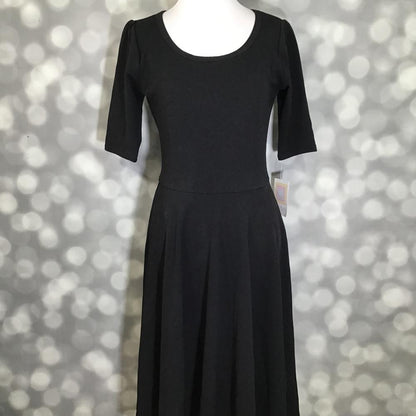 LuLaRoe Nicole Dress in solid black featuring a fitted bodice, scoop neckline, mid-length sleeves, and a full circle skirt. Women's classic black fit and flare dress designed for workwear, special occasions, church outfits, casual styling, and year-round wardrobe versatility.