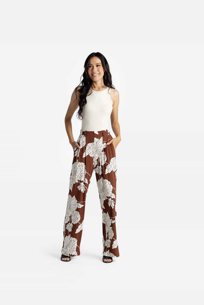 LuLaRoe Pamela Trouser in brown with large ivory floral print, wide leg flowy pants styled with neutral sleeveless top on a white background