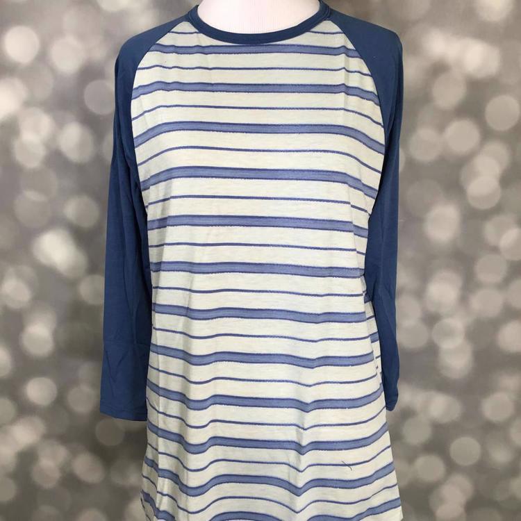 LuLaRoe Randy Tee with blue and ivory horizontal stripes and navy long sleeves on a mannequin with blurred gray bokeh background