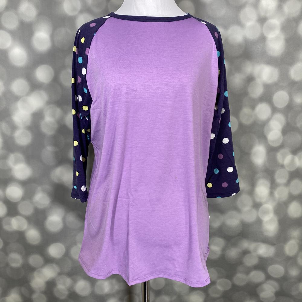 LuLaRoe Randy Tee with lavender body and navy polka dot raglan sleeves on a mannequin against a gray background
