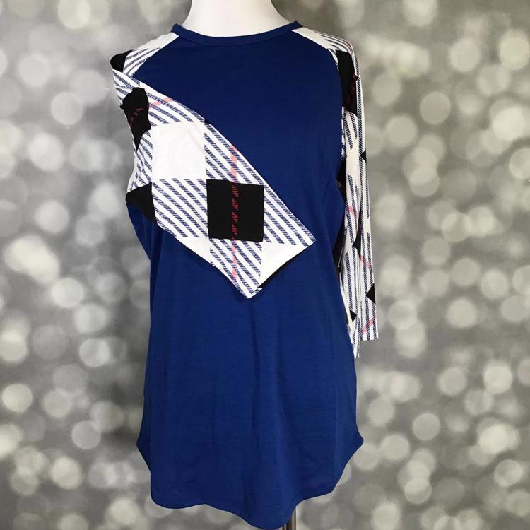 LuLaRoe Randy Tee with navy body and geometric striped contrast sleeves on mannequin on a gray blurred background