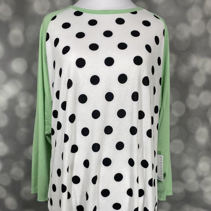 LuLaRoe Randy Tee with mint green sleeves and black polka dots on cream body on a mannequin against a blurred background