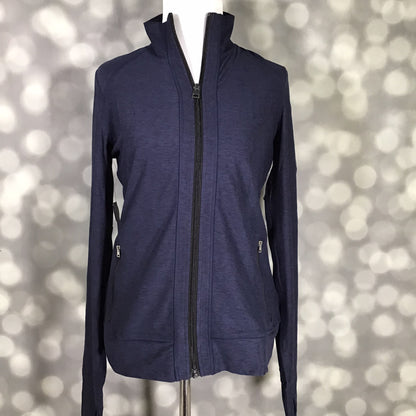 LuLaRoe Rise Bold Jacket in solid midnight navy blue displayed on a mannequin with a full zip front, high collar, long sleeves, and zippered pockets against a gray bokeh background. Sleek athletic performance jacket with a fitted silhouette perfect for layering, travel, workouts, and athleisure styling. 