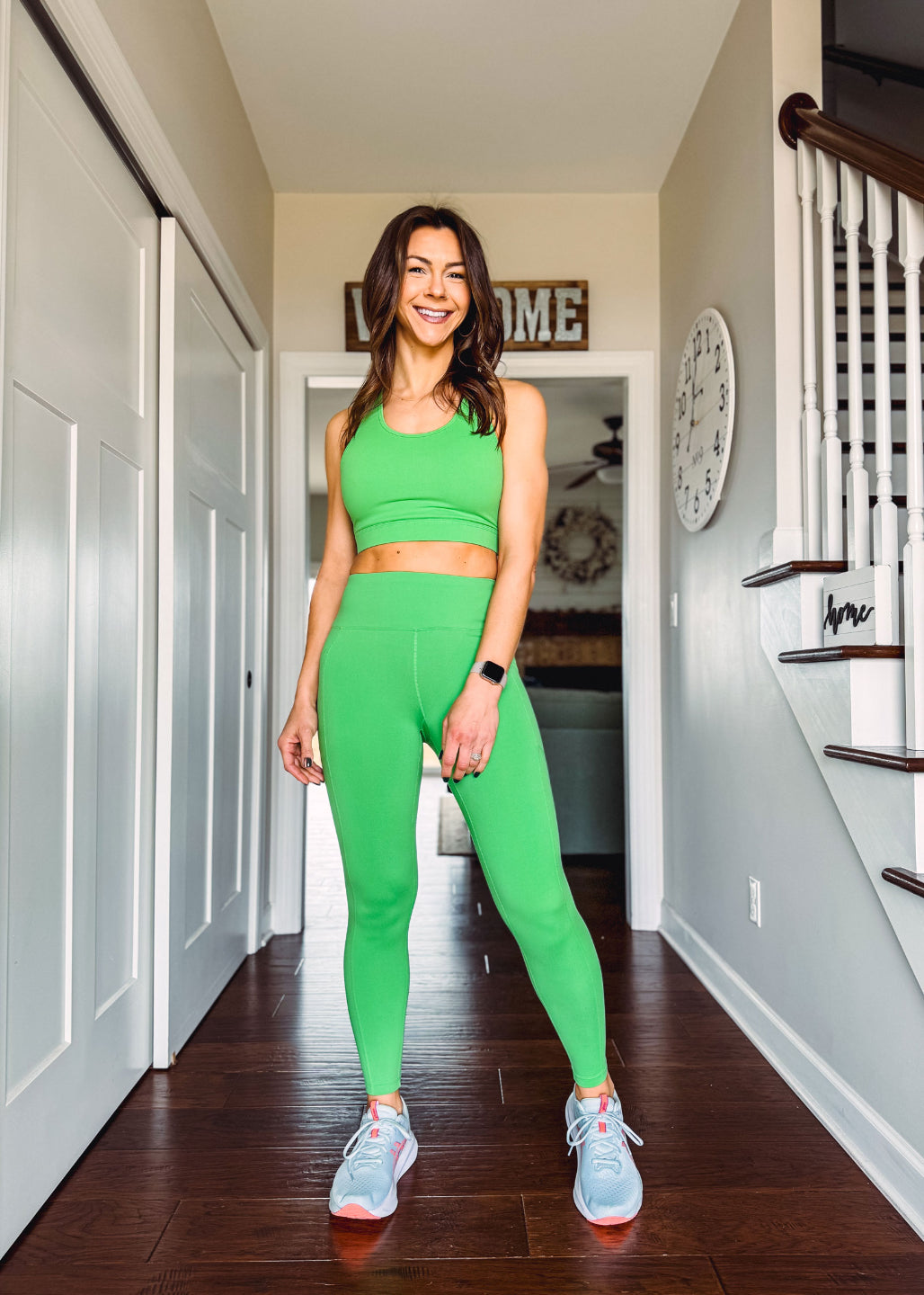 Woman wearing LuLaRoe Rise Brave leggings and sports bra in solid kelly green standing indoors in athletic outfit