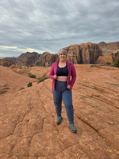 Model wearing LuLaRoe Rise Infinite Jogger in slate blue with a relaxed athletic fit, elastic waistband, and tapered jogger leg.