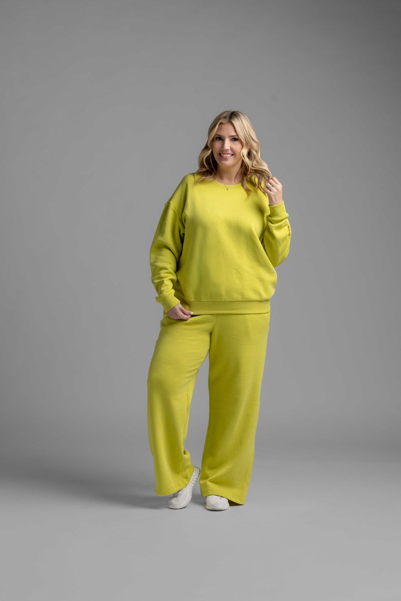 LuLaRoe RISE Recharge Pull-On Sweatpant in Citrus Bloom Statement bright citrus yellow fleece with relaxed wide-leg fit, styled as matching lounge set against neutral studio background.