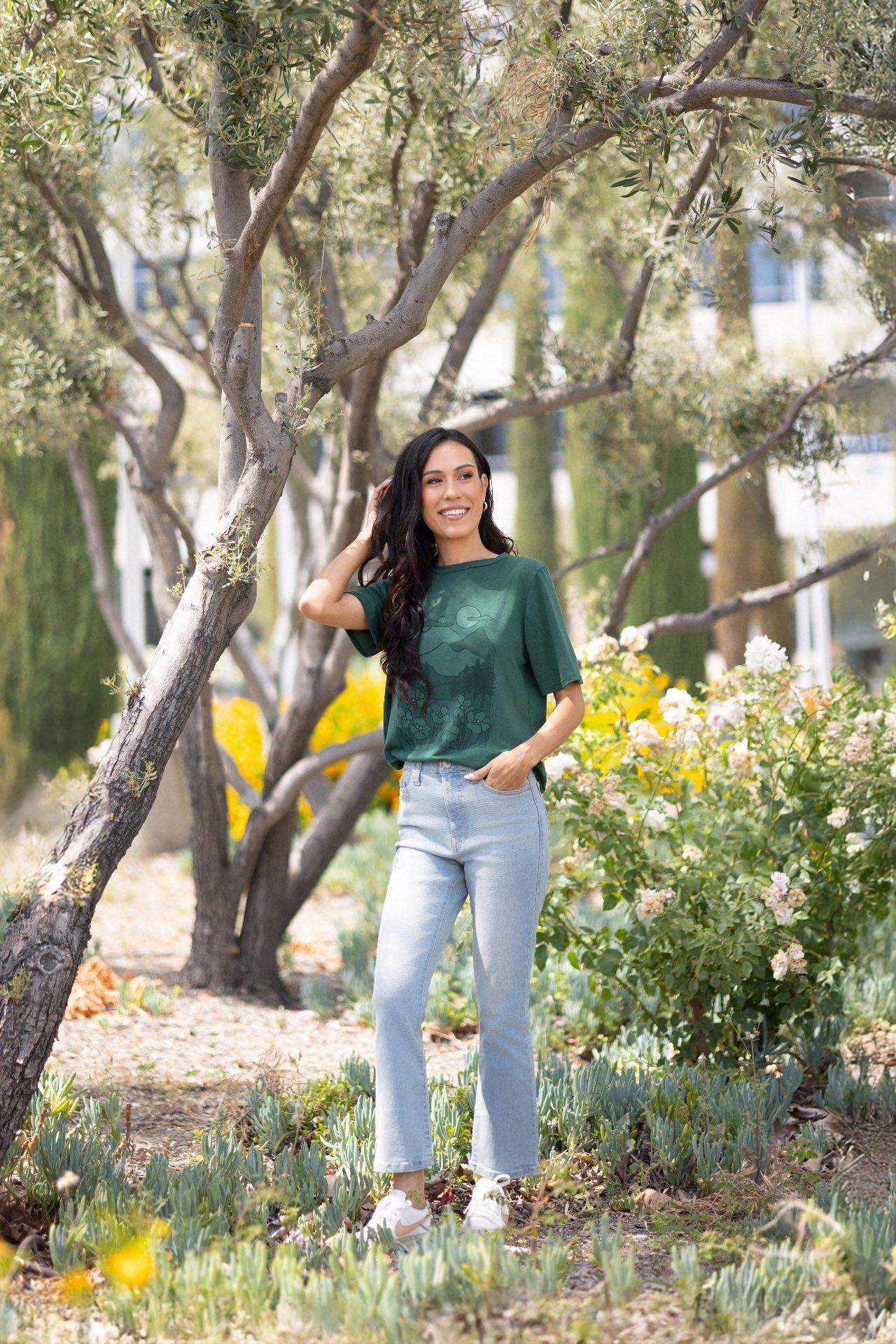 LuLaRoe Rivkah Top in forest green featuring a mountain landscape graphic with pine trees, wildflowers, moonlit sky, and outdoor adventure artwork. Relaxed short sleeve women's graphic top inspired by nature, hiking, camping, and mountain scenery.