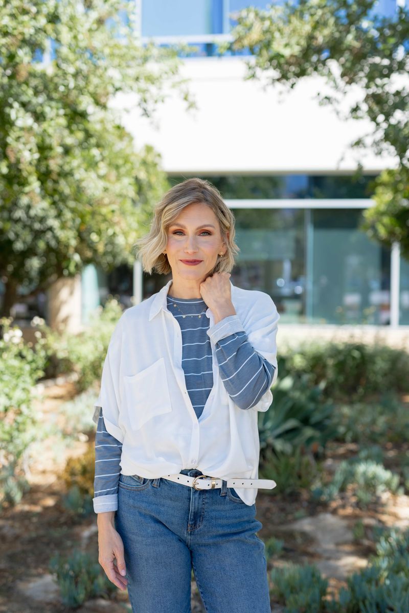 Model wearing a blue and white striped long sleeve LuLaRoe Sharon Top with a relaxed fit, shown outdoors with denim jeans.