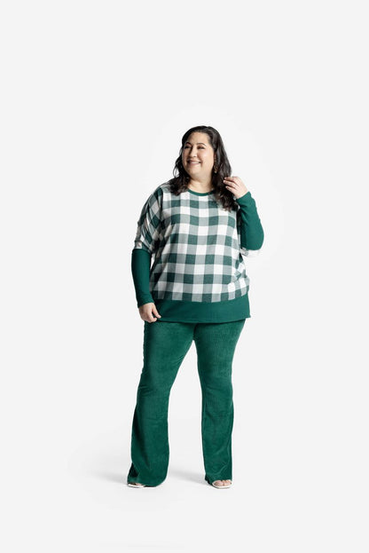 Model wearing LuLaRoe Tammy Top with green and white buffalo check print and ribbed green cuffs on a white background