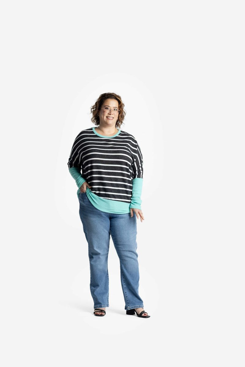 Model wearing LuLaRoe Tammy Top with black and white stripes and aqua trim on a white background