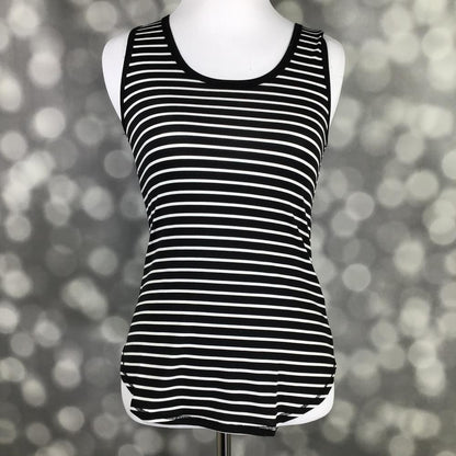 LuLaRoe tank top in Classic Black White Stripe featuring black fabric with thin white horizontal stripes, sleeveless styling, scoop neckline, and a curved hem on a mannequin against a blurred background. Timeless striped women's tank top ideal for layering, casual outfits, and capsule wardrobes.