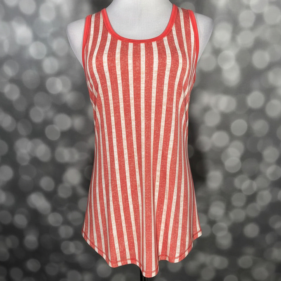 LuLaRoe coral and cream vertical striped tank top with scoop neckline, sleeveless design, and relaxed fit displayed on a mannequin against a blurred background