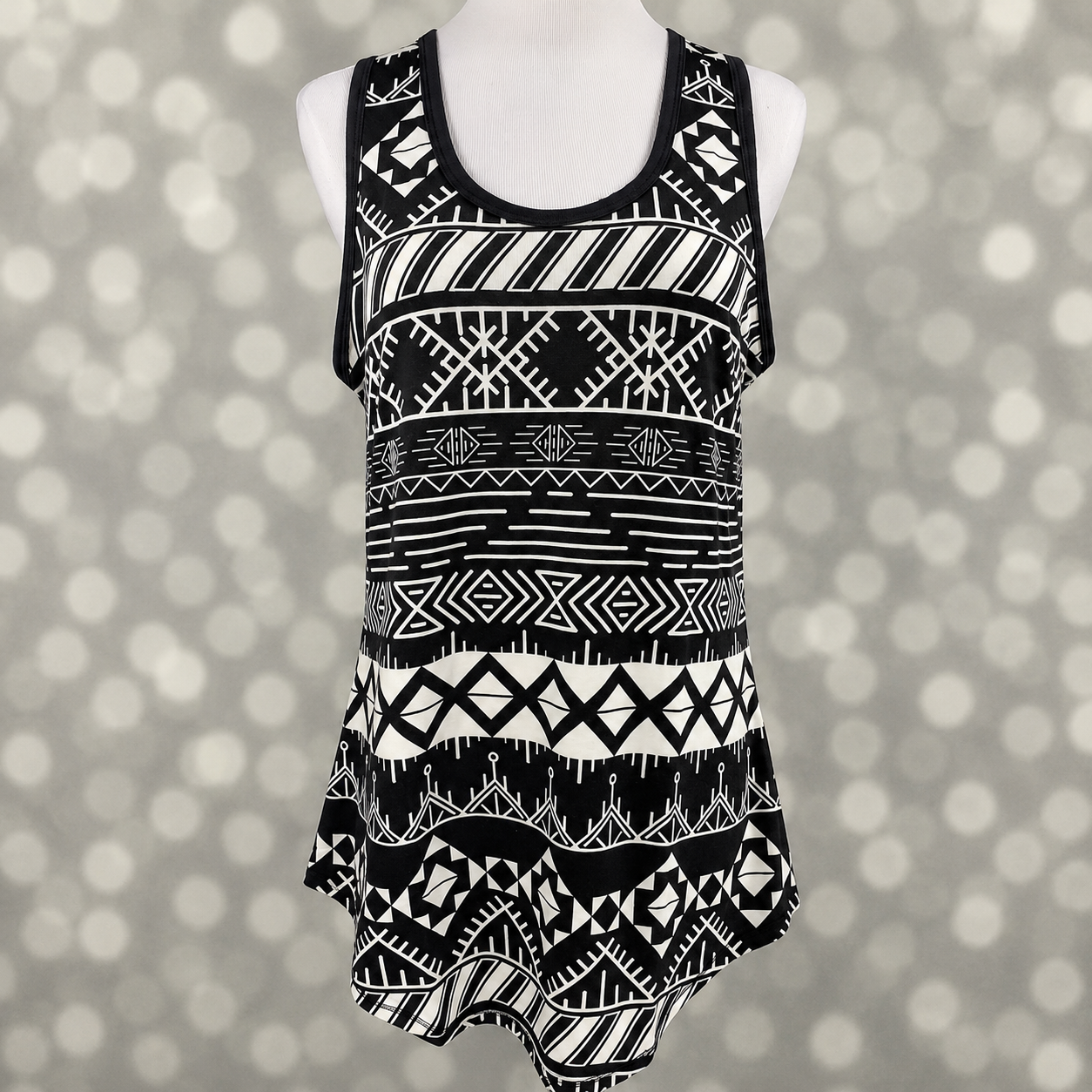 LuLaRoe tank top in Monochrome Mesa Mosaic featuring a bold black and white southwestern geometric pattern with tribal-inspired motifs, sleeveless styling, scoop neckline, and a relaxed fit. Women's boho tank top ideal for casual outfits, summer fashion, and everyday wear on a mannequin against a gray background