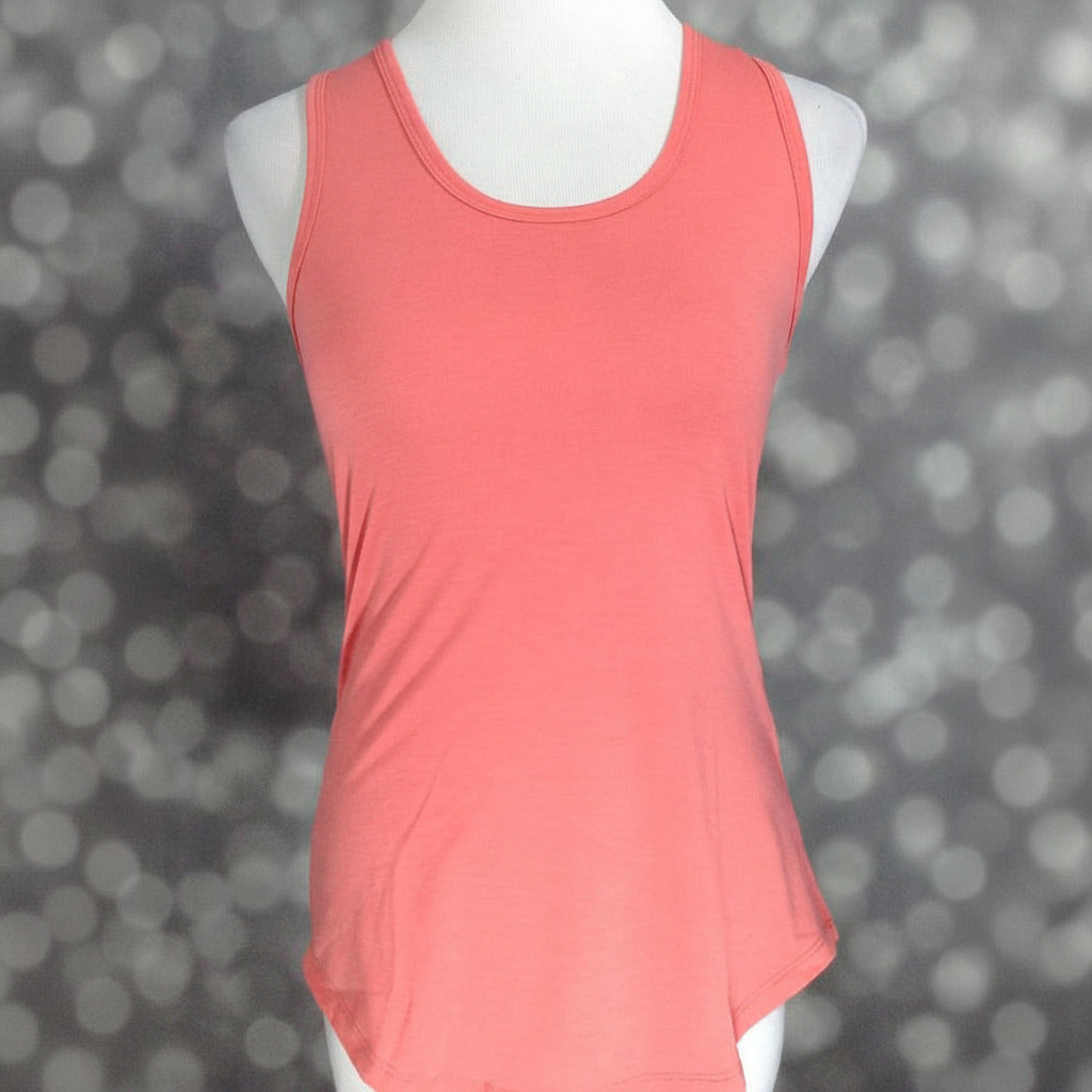 LuLaRoe solid soft coral pink tank top with scoop neckline, sleeveless design, and relaxed fit displayed on a mannequin against a blurred gray background