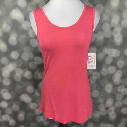 LuLaRoe solid coral pink tank top with scoop neckline, sleeveless design, and relaxed fit displayed on a mannequin against a blurred gray background