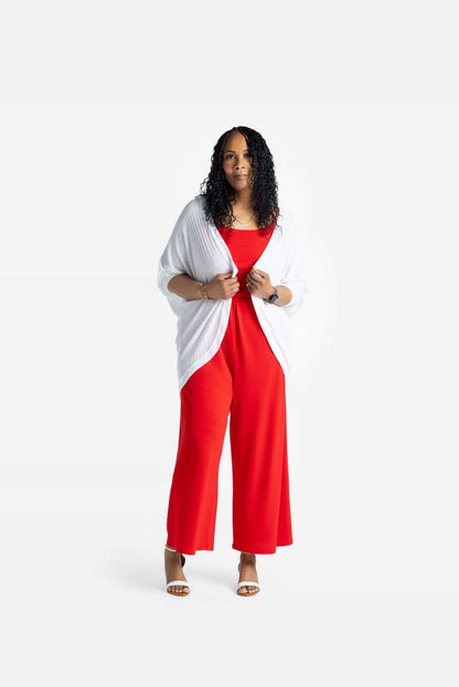 Model wearing LuLaRoe Tracy cocoon cardigan in solid white layered over a red outfit, featuring a relaxed draped fit and lightweight ribbed texture styled with heeled sandals on a neutral background.