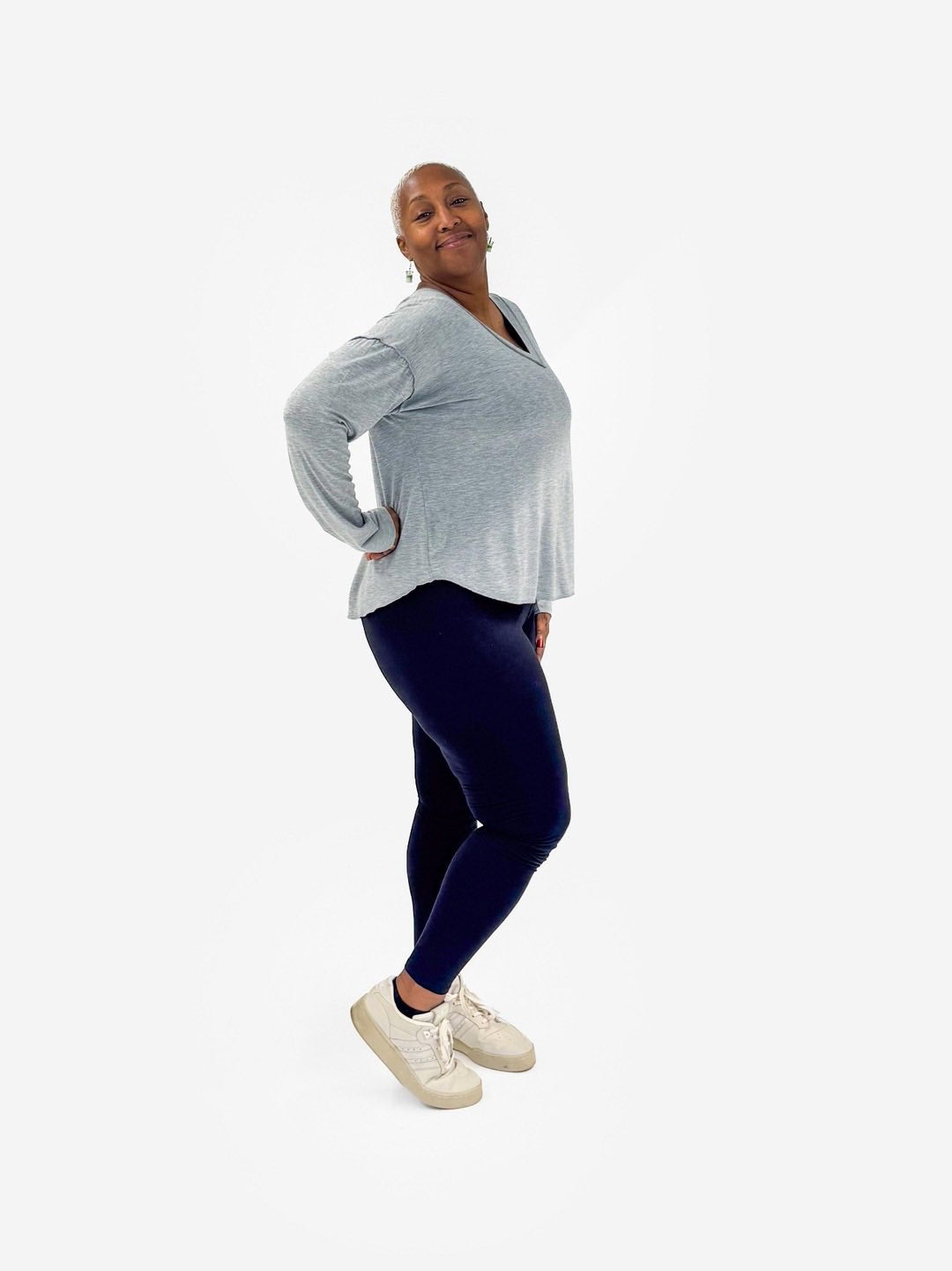 Woman wearing a LuLaRoe Vicki Top in heathered light gray with a raw-edge V-neck, long sleeves, and relaxed fit on a white background.