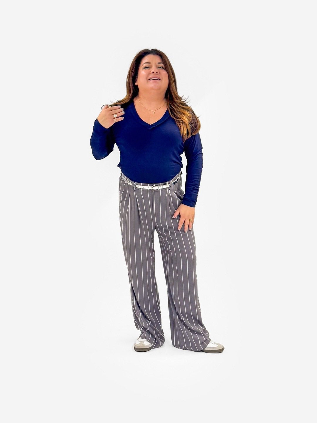 Woman wearing a LuLaRoe Vicki Top in solid classic navy with a raw-edge V-neck, long sleeves, and relaxed fit on a white background.