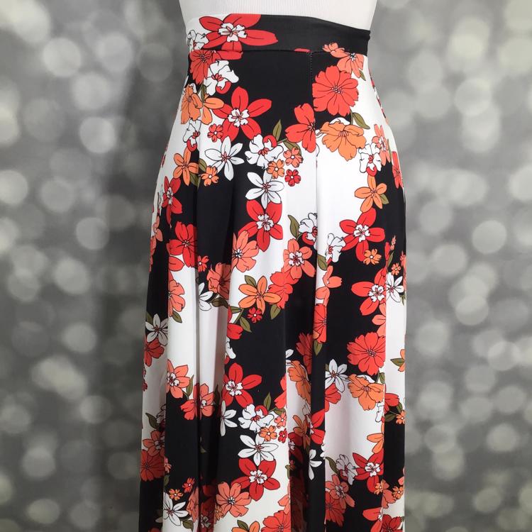 LuLaRoe Victoria skirt with black and white vertical stripes and coral orange floral print, featuring an elastic waistband and flowy midi silhouette displayed on a mannequin