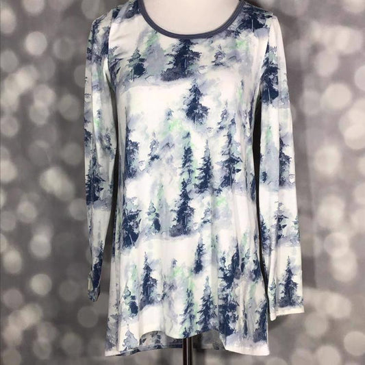 Front view of mannequin wearing LuLaRoe Lynnae Top in white fabric with watercolor-style pine tree print in blue and green tones