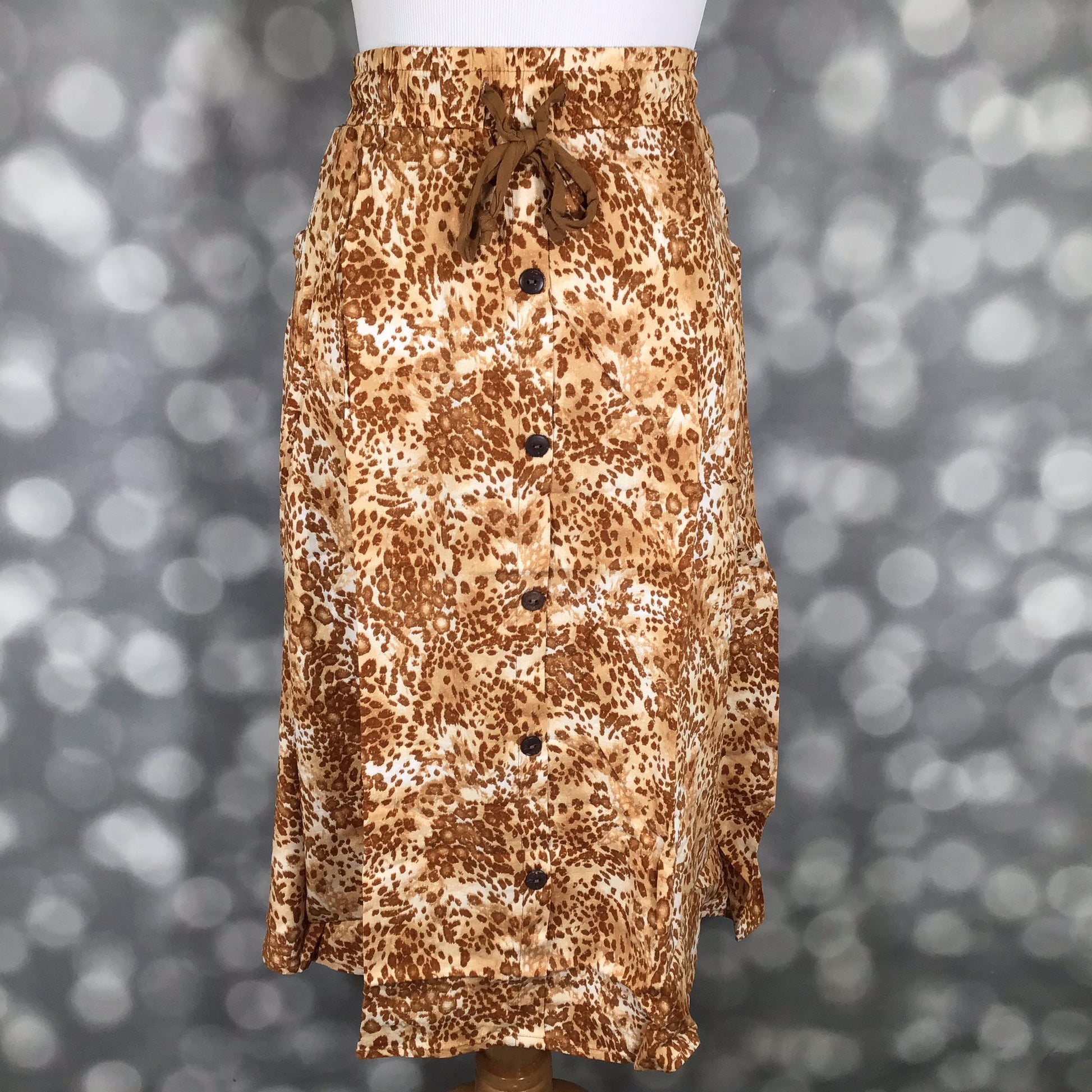 LuLaRoe Marsha Skirt in Sahara Drift featuring a warm tan and brown neutral animal-inspired abstract print with button-front detail and relaxed fit