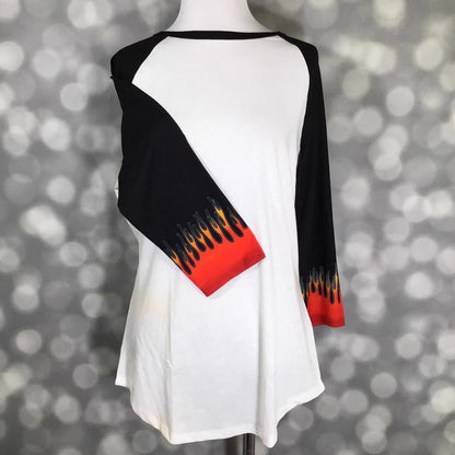 LuLaRoe Randy Tee with white body, black raglan sleeves, and red flame graphic cuffs on a mannequin with a gray blurred background