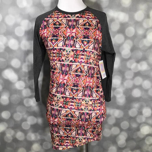 LuLaRoe Randy Tee Mosaic Ember Geometry featuring bold geometric pattern with dark contrast sleeves on a mannequin on a gray blurred background.