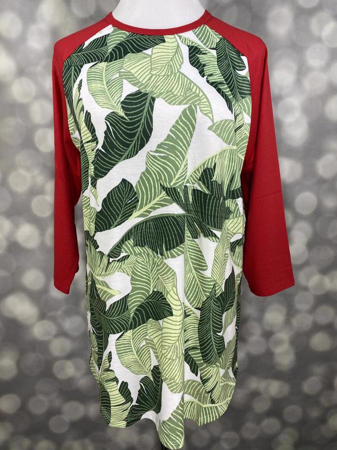 Front view of LuLaRoe Randy T on mannequin featuring white body with bold green tropical leaf print and contrasting red raglan sleeves