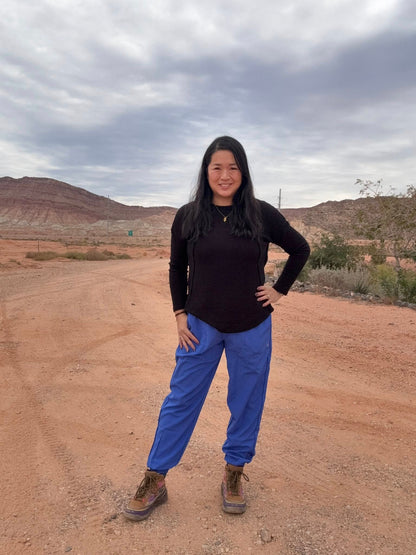 Model wearing LuLaRoe Rise Infinite Jogger in solid cobalt blue with elastic waistband and ankle cuffs