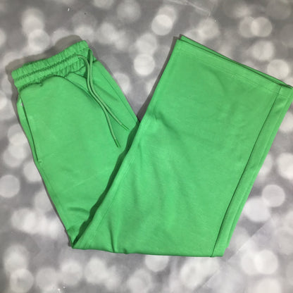 RISE Recharge pull-on sweatpant in solid fresh clover green with a high-rise elastic waistband and relaxed wide leg on a gray surface with a blurred background