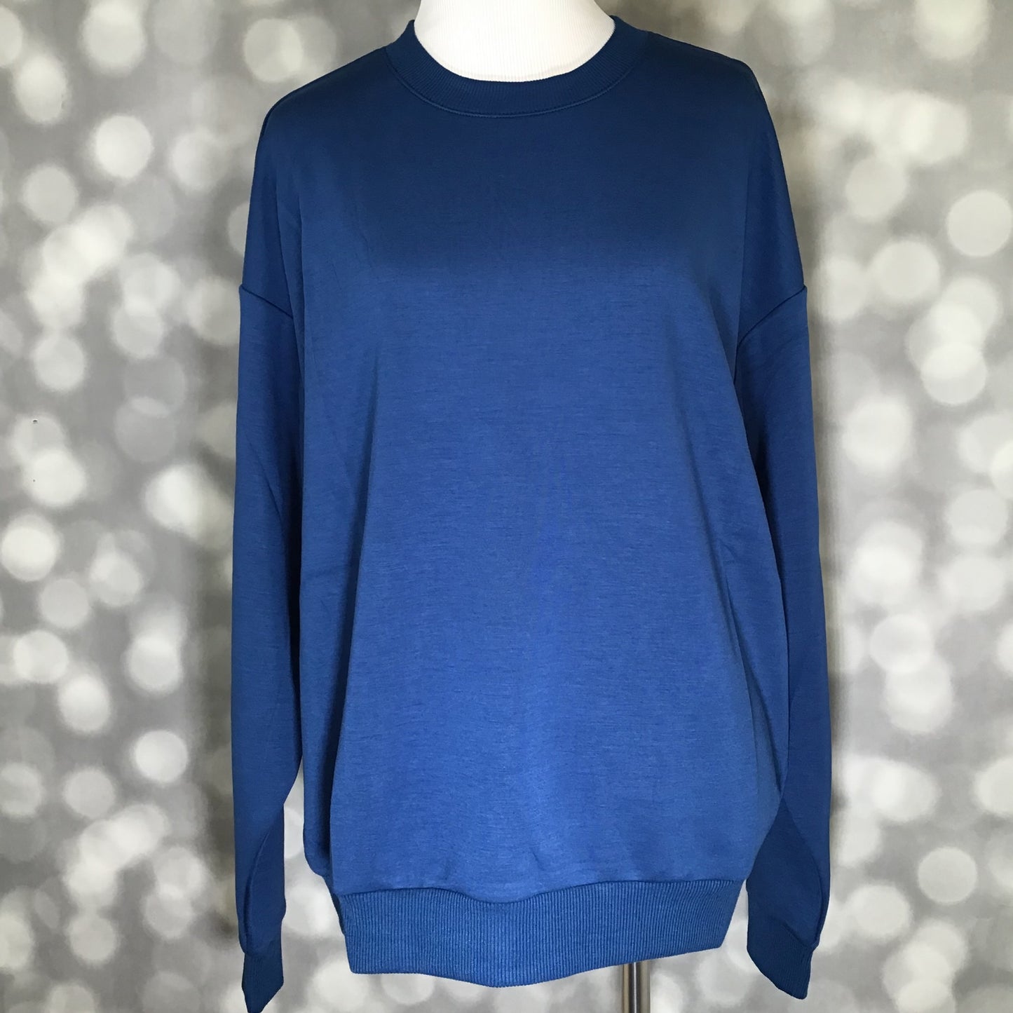 Solid classic blue long sleeve crewneck pullover featuring drop shoulders and soft scuba fabric.