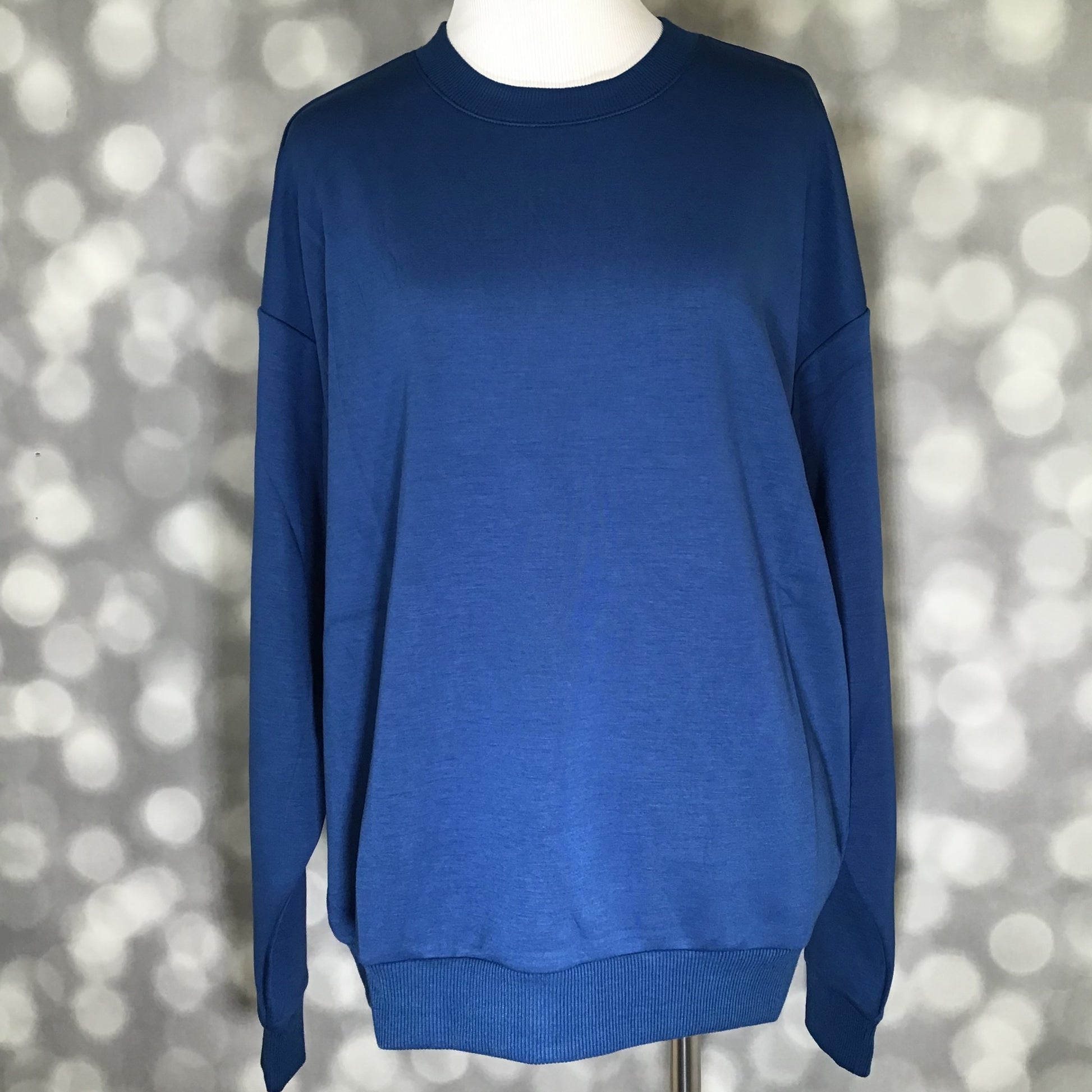 Solid classic blue long sleeve crewneck pullover featuring drop shoulders and soft scuba fabric.